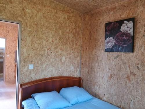 a bed with two blue pillows in a bedroom at Gîte Bleu Confort et Nature in Sennecey-le-Grand