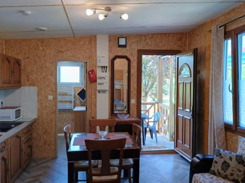 a kitchen with a table and a dining room at Gîte Bleu Confort et Nature in Sennecey-le-Grand