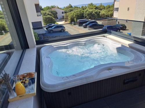 a hot tub on a balcony with a view of a parking lot at Villa Excellente in Mandre