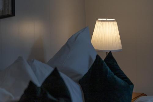 a bed with blue and white pillows and a lamp at Chesa-strimer - Rustica in La Punt-Chamues-ch