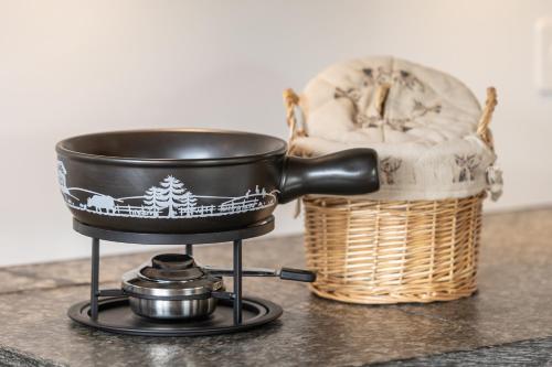 a pot on a stove next to a basket at Chesa-strimer - Rustica in La Punt-Chamues-ch