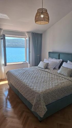 a bedroom with a large bed with a large window at Villa M in Neum