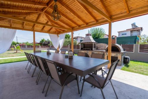 a table and chairs on a patio with a grill at MiCasa Palace in Korinós