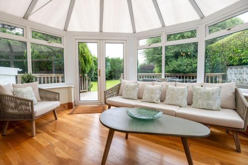 a living room with a white couch and windows at Mountain View in Moelfre