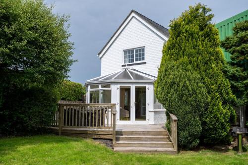 a white house with a porch and a fence at Mountain View in Moelfre