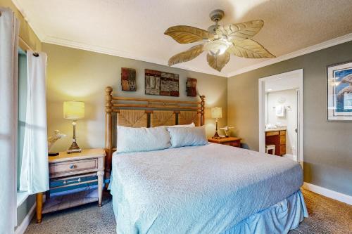 una camera da letto con un letto e un ventilatore a soffitto di Patio Condo in Oceanfront Community w/ Pool – Walk to Beach a St. Augustine