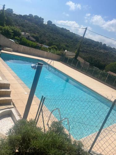 une piscine bleue entourée d'une clôture dans l'établissement Mèr et montagne, à Villeneuve-Loubet