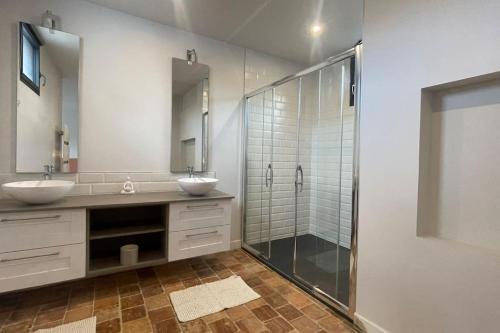 a bathroom with two sinks and a glass shower at Le Loft des Lumières in Château-Gontier