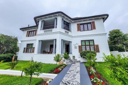 a white house with a garden at CasaMia in Bredasdorp