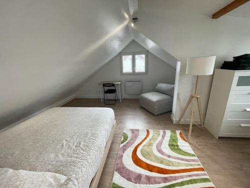 Cette chambre mansardée comprend un lit et un canapé. dans l'établissement Maison proche de Paris, à Vanves