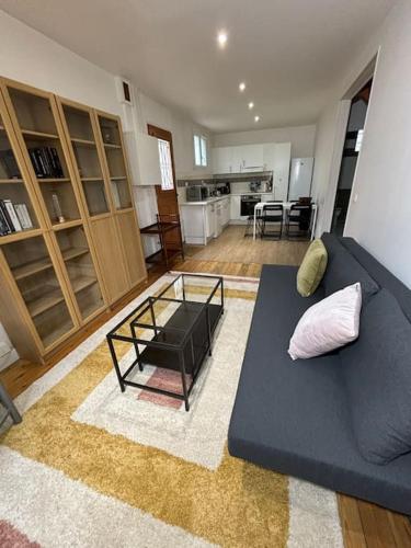 un salon avec un canapé bleu et une table dans l'établissement Maison proche de Paris, à Vanves