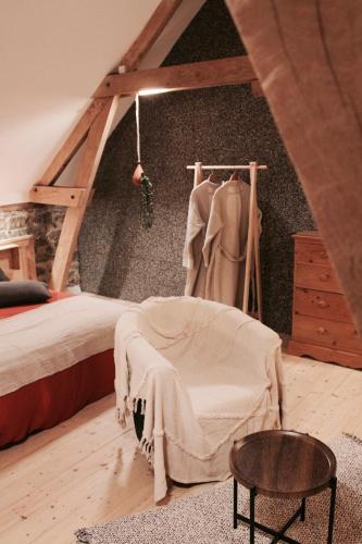 - une chambre mansardée avec un lit et une commode dans l'établissement Duplex accès jacuzzi illimité, à Villedieu-les-Poêles