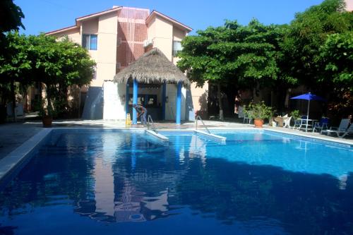 a large blue swimming pool with a building at Departamento bonito en Huatulco in Santa Cruz Huatulco