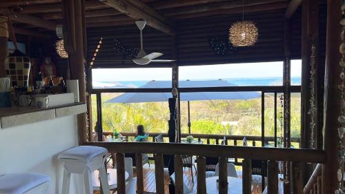 a room with a balcony with a view of the ocean at Horizon Hotel & Yoga Center in Santa Teresa Beach
