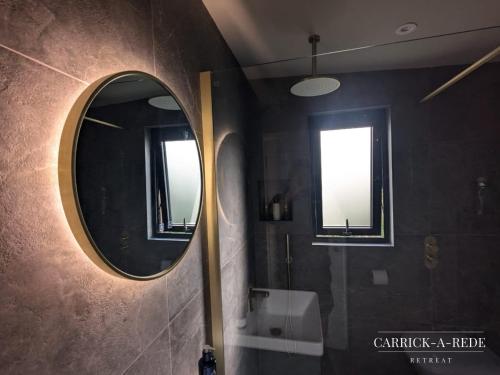 a bathroom with a mirror and a sink at Carrick-a-Rede Luxury Retreat Ballintoy Causeway Coast in Ballintoy