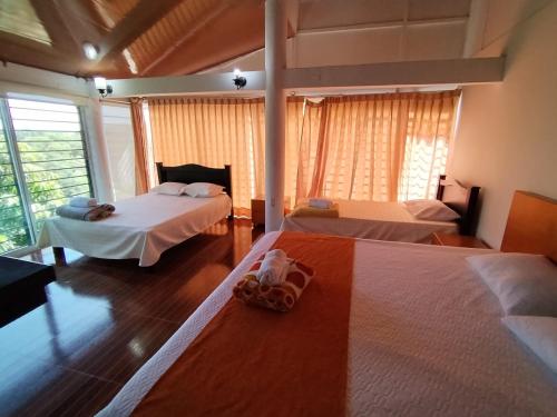 a bedroom with two beds and a window at Hotel El Bosque Valledupar in Valledupar