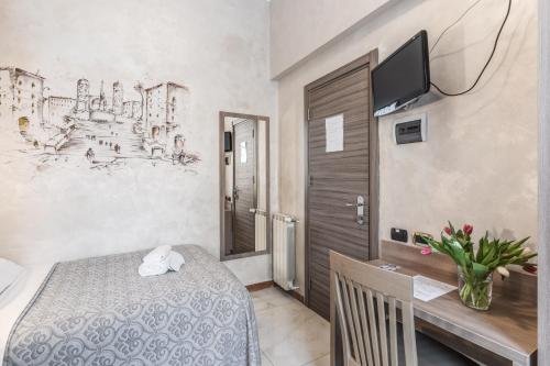 a bedroom with a bed and a desk with a television at Hotel Centro Cavour Roma in Rome