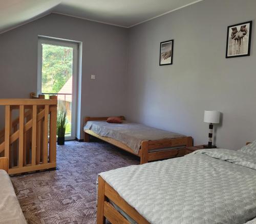 a bedroom with two beds and a window at Apartament na Frezjowej in Gdańsk