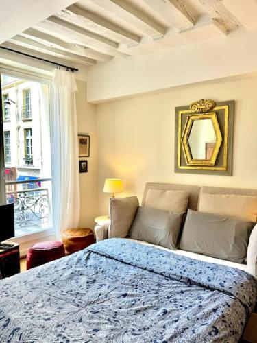 une chambre avec un lit bleu et une fenêtre dans l'établissement Beautiful flat in Saint-Germain, à Paris