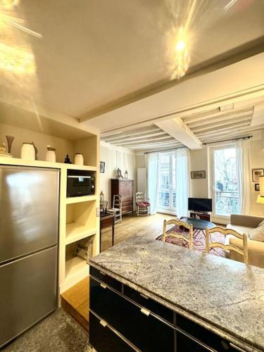 une cuisine et un salon avec un réfrigérateur en acier inoxydable dans l'établissement Beautiful flat in Saint-Germain, à Paris