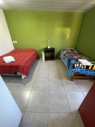 a room with two beds and a green wall at departamento nicolay in Junín