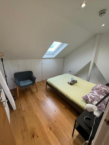 a bedroom with a bed and a chair in it at Lovely flat in Brockley, SE4 in London