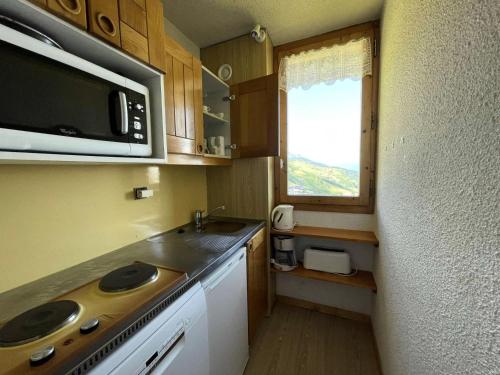 une petite cuisine avec un évier et un micro-ondes dans l'établissement Résidence Cristallin - Le Cristallin 46 - 2 pièces offrant une vue magnifique MAE-5284, à Valmorel