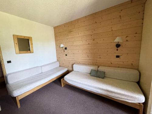 une pièce avec deux canapés blancs devant un mur en bois dans l'établissement Résidence Cristallin - Le Cristallin 43 - Agréable 2 pièces offrant une magnifique vue MAE-5184, à Valmorel