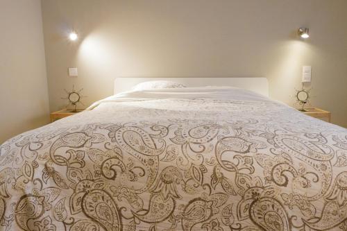 a bedroom with a large bed with a white comforter at La maisonnette du Prince in Bruges
