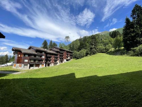 un grand bâtiment sur une colline avec un champ verdoyant dans l'établissement Résidence Pierrer - Le Pierrer 13 - Studio divisible, vue pistes et montagne MAE-5574, à Valmorel