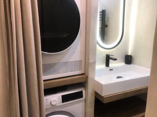La salle de bains est pourvue d'un lavabo, de toilettes et d'une télévision. dans l'établissement Résidence Pierrer - Le Pierrer 78 - Appartement cosy, totalement rénové, classé 3 étoiles MAE-6224, à Valmorel