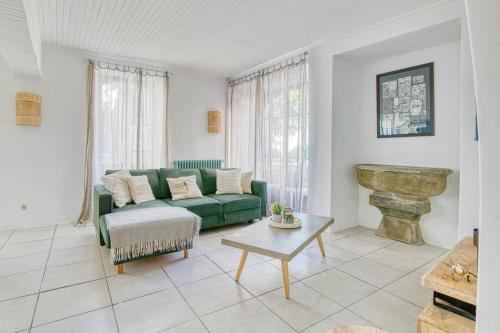 a living room with a green couch and a table at «Coeur de vie » logement hyper centre de Bagnères de Bigorre in Bagnères-de-Bigorre