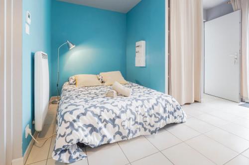 une chambre avec un lit avec un mur bleu dans l'établissement Studio 8 Cap Ouest Vacances, à Pornichet