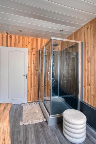 a glass shower in a room with a stool at «Coeur de vie » logement hyper centre de Bagnères de Bigorre in Bagnères-de-Bigorre
