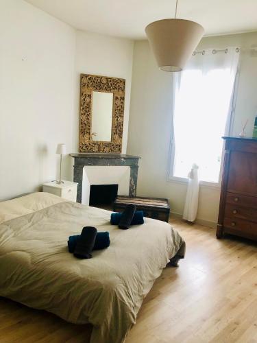une chambre avec un lit avec deux oreillers dessus dans l'établissement Maison de ville au Cœur d'Angoulême- 2 chambres-Wifi- Cosy - Idéal de 1 à 6 Personnes - conciergerie J&N, à Angoulême