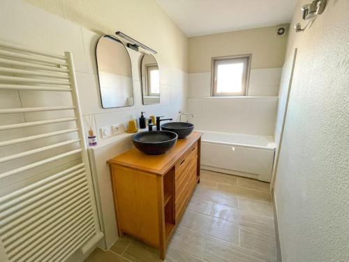 a bathroom with two sinks and a bath tub at Le Saint Gilles Cosy, centre-ville, WIFI in Le Puy en Velay