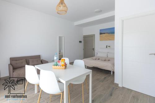 sala de estar con mesa blanca y sillas blancas en Lola Loft 5 Lajares iRent Fuerteventura, en La Oliva
