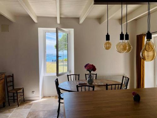 une salle à manger avec une table et une fenêtre dans l'établissement Havre de paix avec vue imprenable sur la mer, à Ploubazlanec