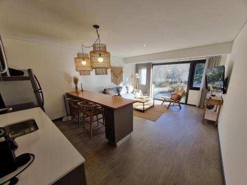 Una cocina y una sala de estar con mesa y sillas. en Ruka 9 Dpto 14 - Andarlibre, en San Martín de los Andes