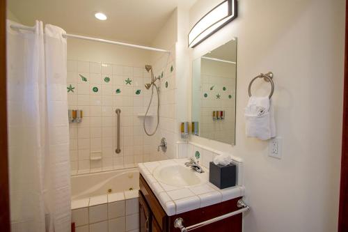 a bathroom with a sink and a shower and a tub at Edgewater Beach Inn in Santa Cruz