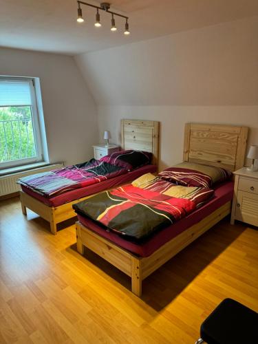 due letti singoli in una stanza con finestra di Ferienwohnungen Augustusburger Straße 149 a Chemnitz