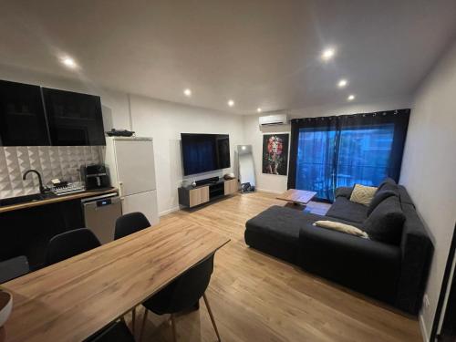 un salon avec un canapé et une table en bois dans l'établissement Appartement Saint-cyprien, à Saint-Cyprien