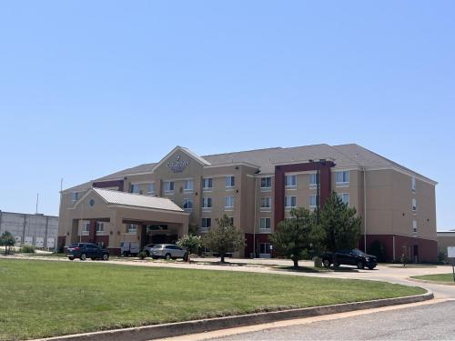 a building with cars parked in front of it at Country Inn & Suites by Radisson, Oklahoma City Airport, OK in Oklahoma City