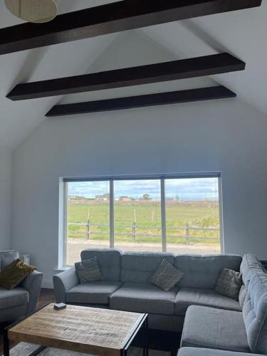 a living room with a couch and a table at Maharees Holiday Home in Castlegregory