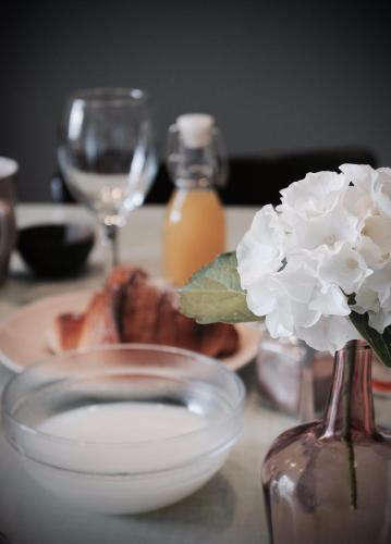 une table avec un vase en verre avec une fleur dans l'établissement Duplex accès jacuzzi illimité, à Villedieu-les-Poêles