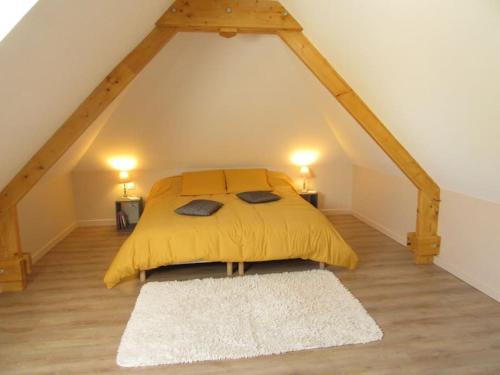 - une chambre mansardée avec un lit jaune dans l'établissement Gîte de la chouette, à Hattenville