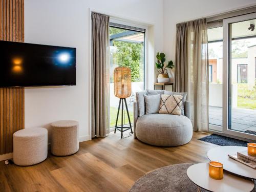 a living room with a chair and a tv at Holiday Home in Voorthuizen near Forest in Voorthuizen