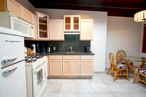 a kitchen with white appliances and a table in it at Edgewater Beach Inn in Santa Cruz