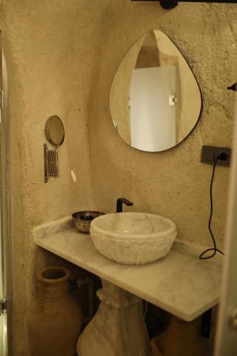 a bathroom with a sink and a mirror at Potamia Cave Suites in Ortahisar