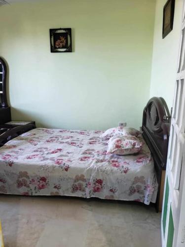 a bedroom with a bed with a floral bedspread at studio confortable in Tabarka
